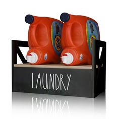 two orange toy cars sitting on top of a black box with laundry written on it