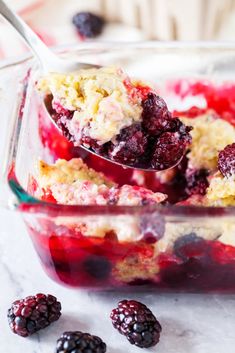 berry cobbler in a glass dish with a spoon