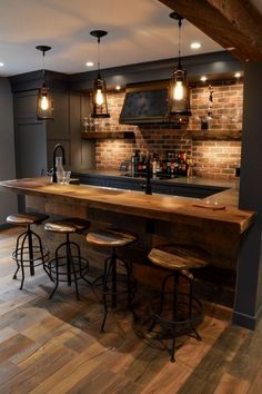 a bar with stools in the middle of it and lights hanging from the ceiling