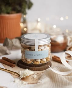 a jar filled with nuts sitting on top of a table next to ribbon and other items