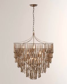 a chandelier hanging from the ceiling with wooden sticks attached to it and some lights on