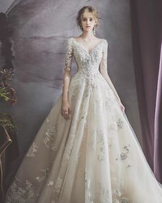 a woman in a wedding dress standing next to a window