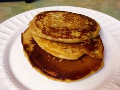 three pancakes stacked on top of each other on a white plate with paper plates underneath