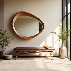 a wooden bench sitting in front of a round mirror on the wall next to a potted plant