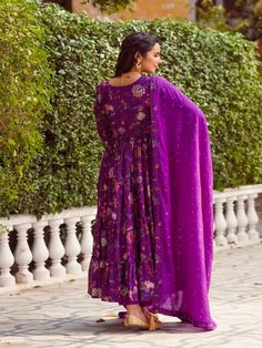 This Set Has a Anarkali, bottom and dupatta. Floral printed tier Anarkali set with hand embroided yoke. It is paired with matching chanderi foil print dupatta enhanced with fabric detailing and palazzo pants. Color: Purple Fabric: Anarkali - Cotton Silk Bottom - Shantoon Dupatta - Chanderi Product Details: Neck Type - Round neck Anarkali Length - 50 inches Bottom Length - 38-40 inches Sleeve Length - 22 inches Note: Available in other colors The product will be delivered within 2-4 weeks of orde Transitional Anarkali Set With Dupatta In Georgette, Transitional Georgette Anarkali Set With Dupatta, Traditional Drape Sharara With Sheer Dupatta, Traditional Mulmul Sharara With Sheer Dupatta, Purple Anarkali Palazzo Set With Cutdana, Silk Palazzo Set With Dupatta In Maxi Length, Designer Georgette Sharara With Printed Motifs, Traditional Drape Palazzo Set With Printed Motifs, Purple Chanderi Palazzo Set With Sheer Dupatta