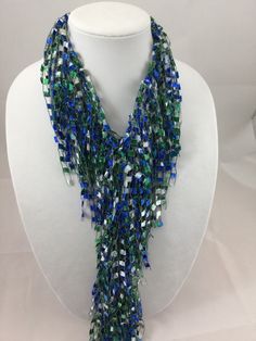 A beautiful and unique handmade accessory that shimmers and portrays a beaded look! Each Fringed Scarf Necklace is handmade and can be worn multiple ways. Item is lite weight and is available in many stunning great colors. Comes packaged in an organza bag. A great gift item. Fringed Scarf Necklace is approx. 66 inches in length and is made of 97% Nylon and 3% Lurex. Handwash in cold water and lay flat to dry. Each item is made by hand and slight variations may occur. Green Statement Necklace, Scarf Necklace, Fringe Scarf, Necklace Statement, Organza Bags, Handmade Accessories, Sweater Coats, Infinity Scarf, Blue And Green