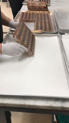 a person in white gloves is making waffles on a table with other people