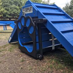 there is a blue play structure with paw prints on the front and bottom half of it