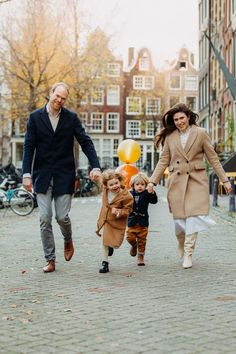 a family walking down the street with balloons