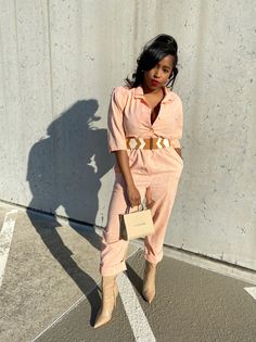 This peach jumpsuit is one of those quintessential vintage pieces. It has a cinched waist, button closures, and structured shoulders. Pair this jumpsuit with your favorite tan accessories for a fun neutral color palette.  * Size M-L * Peach color * Button closures * Structured shoulders Mila & Fire is an online store full of contemporary, vintage, & reconstructed threads that exude an energy of individualism and style. Chic Beige Jumpsuits And Rompers For Day Out, Pink Retro Jumpsuits And Rompers For Spring, Retro Summer Jumpsuits And Rompers For Work, Retro Summer Workwear Jumpsuits And Rompers, Trendy Beige Workwear Jumpsuits And Rompers, Trendy Beige Jumpsuits For Work, Vintage Summer Jumpsuits And Rompers For Work, Orange Jumpsuits And Rompers For Spring Day Out, Vintage Jumpsuits And Rompers For Summer Workwear