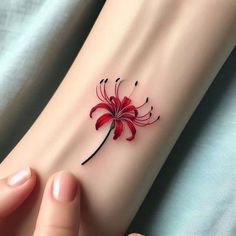 a woman's arm with a red flower tattoo on it