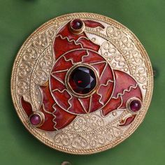 The famous 6th century Triskelion Brooch, as shown in Sutton Hoo collection in British Museum in London, is remarkably ,is reproduced in this vermeil pin, pendant and earrings. Crafted totally by hand as done in the ancient times. The Cloisonne motif is three whirling arms in the form of birds' heads. The eyes of the b Ceremonial Medallion Jewelry With Historical Design, Traditional Yellow Gold Pendant Brooches, Traditional Yellow Gold Collectible Brooch, Traditional Medallion Jewelry With Historical Design, Antique Pendant Brooch With Intricate Design, Antique Brooch With Intricate Pendant Design, Byzantine Coin Jewelry For Ceremonial Occasions, Byzantine Style Coin Jewelry For Ceremonial Use, Gold Medallion Jewelry With Historical Design