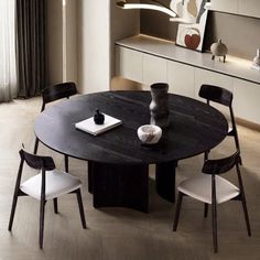 a round table with four chairs around it in a room that has white walls and flooring