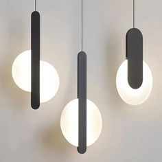 three lights hanging from the ceiling with different shapes and sizes on them, one light is dim