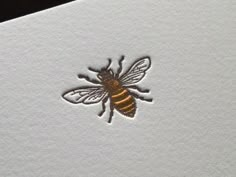 a close up of a bee on a piece of paper