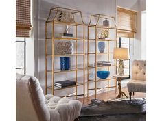 a living room filled with furniture and a book shelf next to a chair in front of a window