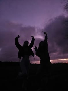 two people standing in front of a purple sky