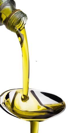 olive oil being poured into a glass bowl