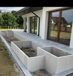 an unfinished concrete wall in front of a house