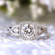 an engagement ring with a diamond center surrounded by diamonds