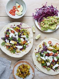 four pita breads with different types of toppings on wooden cutting board next to each other