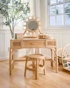 a wooden desk with a mirror, stool and potted plant in front of it