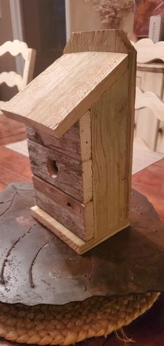 a wooden bird house sitting on top of a rock