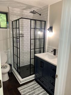 a bathroom with a shower, sink and rugs on the floor in front of it