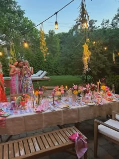 a group of women standing around a table covered in flowers