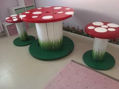 three red and white mushrooms sitting on top of green bases