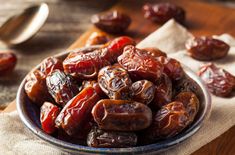 a bowl filled with raisins on top of a wooden table