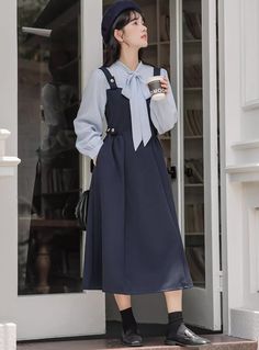 Preppy twofer midi dress with a faux layered look. Features tie neck blouse with long sleeves, a cami pinafore bodice with side pockets and embellished with golden buttons. Concealed side zipper closure. S: 33" chest, 26" waist, 44" lengthM: 34.5" chest, 27.5" waist, 44" lengthL: 36" chest, 29" waist, 44.5" lengthXL: 37.5" chest, 30.5" waist, 44.5" length Midi Dress Navy, Blouse With Long Sleeves, Tie Neck Blouse, Navy Midi Dress, Overall Dress, Sweater Blouse, Layered Look, Tie Neck, Cardigan Jacket