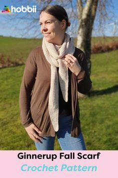 a woman standing in front of a tree wearing a scarf