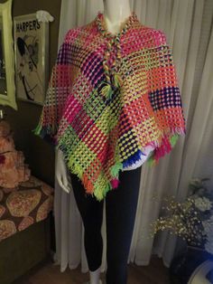 "1970's bright colorful patchwork look crocheted cape/poncho, with fringed edge/ neckline, and braided neckline edge with ties. Poncho has a one way entryover the head! But for a small head fit....22\". The poncho yarn colors are red, orange, white, pink, dark blue, mint, lime, yellow. There is no size or label maker, and this item could be hand made. My size guess is for a petite/small, maybe medium fit, with small head 22\". Great condition. PRICE IS $45.00----SALE FINAL/AS IS/NO RETURNS." Multicolor Tassel Poncho For Winter, Winter Multicolor Poncho With Tassels, Multicolor One Size Poncho For Festivals, One Size Multicolor Poncho For Festival, Multicolor One-size Festival Poncho, Multicolor Fringe Poncho For The Beach, One Size Multicolor Crochet Poncho, Multicolor Fringe Poncho For Beach, Multicolor Crochet Poncho One Size