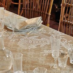 the table is set with glasses, plates and napkins