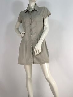 "Vintage khaki dress, button front dress, squeeze jeans size medium  Measurements:  shoulder 16\"/sleeve 5\"/bust 19\"/waist 15\"/hip 19.5\"/length 32\" mannequin measures 5ft 8\", bust 34\", waist 25\", hip 33\" Please note that vintage clothing sizes can vary greatly.  The Measurements provided  are approximate and are taken lying flat.  I suggest taking a similar garment from your wardrobe and measure it while lying flat.  This way you can compare measurements.  All of our pieces are genuine vintage. Don't forget to enlarge the photos and take a closer look at this genuine vintage item!! International destinations other than US may take 4-6 weeks or longer unless you choose to upgrade shipping for faster delivery. Please note buyer is responsible for any duties, taxes or customs clearan Casual Stretch Dress With Buttons, Fitted Khaki Dresses For Spring, Khaki Mini Dress For Work, Fitted Casual Shirt Dress For Work, Fitted Cotton Solid Color Shirt Dress, Fitted Cotton Shirt Dress, Collared Khaki Shirt Dress With Pockets, Fitted Casual Khaki Dress, Khaki Collared Shirt Dress With Pockets