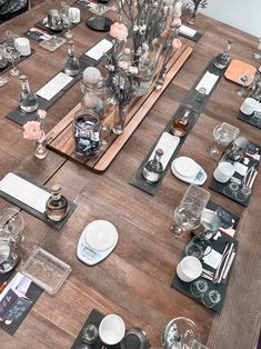 a wooden table topped with lots of plates and glasses