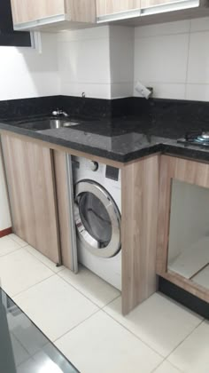 a washer and dryer sitting in a kitchen next to a counter with cabinets