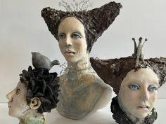 three ceramic busturines with hair on their heads