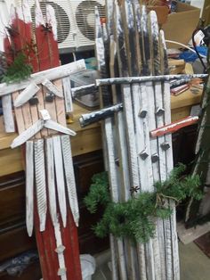 an old fence is decorated with feathers and evergreens for the holiday season, as well as other decorations