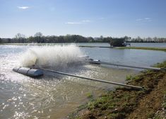 a large pipe is in the middle of a body of water that has been flooded