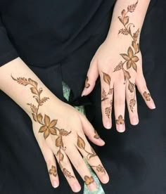 a woman's hands with hennap and flowers painted on her hand,