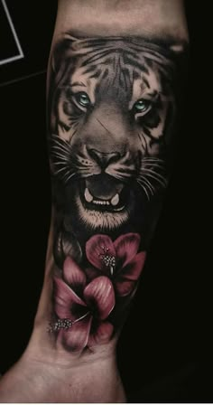 a tiger with blue eyes and flowers on his arm is shown in the instagramt