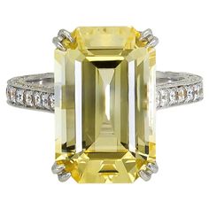 A magnificent engagement ring showcasing a long emerald cut yellow sapphire, set in a diamond encrusted basket and shank. Made in platinum. Yellow Sapphire weighs 11.06 carats. Size 6 US (sizable) Dimensions: 0.62 in x 0.42 in. Elegant Yellow Emerald-cut Diamond Ring, Elegant Yellow Emerald Cut Diamond Ring, Elegant Yellow Sapphire Ring With Brilliant Cut, Elegant Yellow Asscher-cut Ring, Elegant Yellow Asscher Cut Ring, Luxury Rectangular Diamond Ring With Accent Stones, Luxury Emerald Cut Sapphire Ring With Diamond Detail, Yellow Diamond Ring With Emerald Cut Center Stone, Yellow Diamond Ring With Emerald Cut