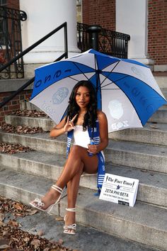 a woman sitting on steps holding an umbrella