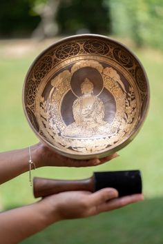 a person holding a metal bowl with an image on the inside and in the middle