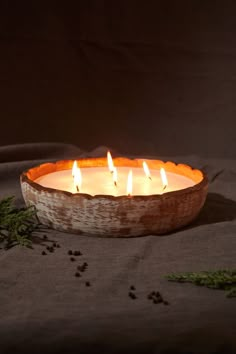 a bowl filled with candles sitting on top of a table