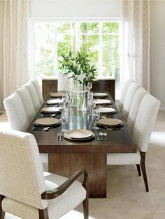 a dining room table is set with place settings for six people and the chairs are upholstered