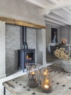 two candles are sitting on a coffee table in front of a fire place and fireplace