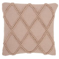 a beige knitted pillow with an argyle pattern on the front and back, sitting on a white background